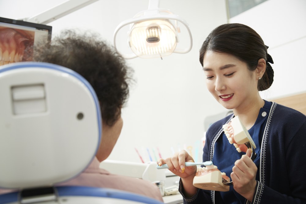 치과위생사가 환자에게 올바른 칫솔질 방법을 교육하는 모습